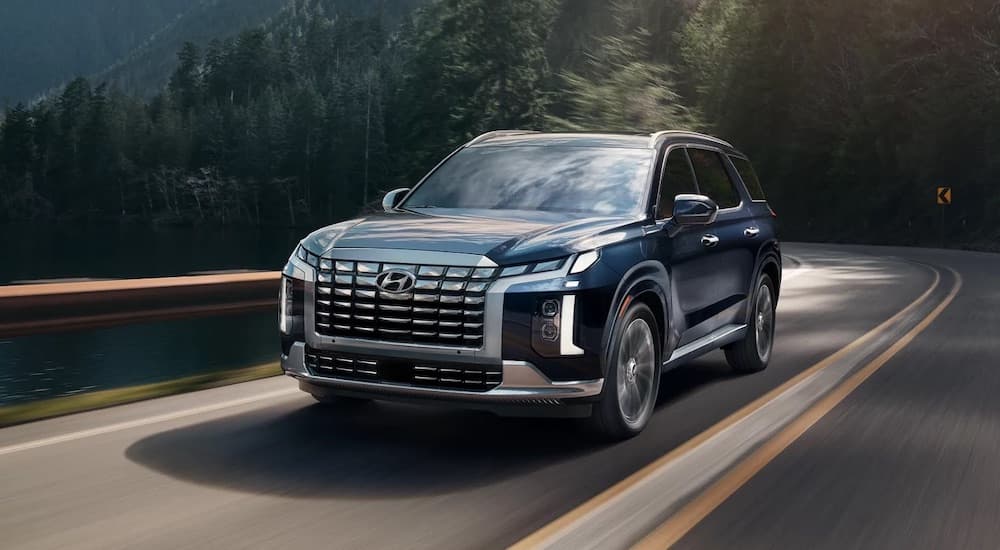 A blue 2024 Hyundai Palisade is shown from the front at an angle after leaving a Hyundai dealer.