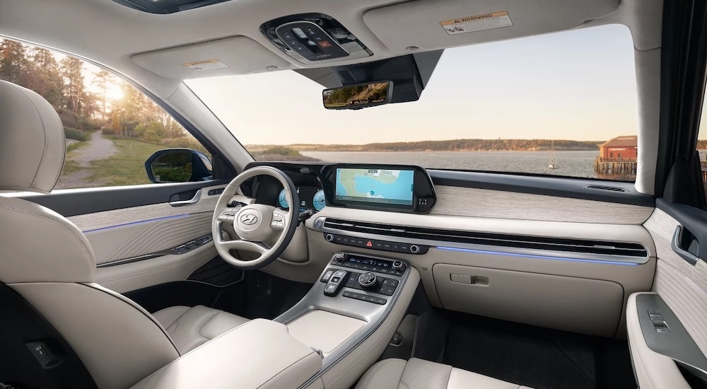 The white interior of a 2025 Hyundai Palisade is shown from the rear seats.