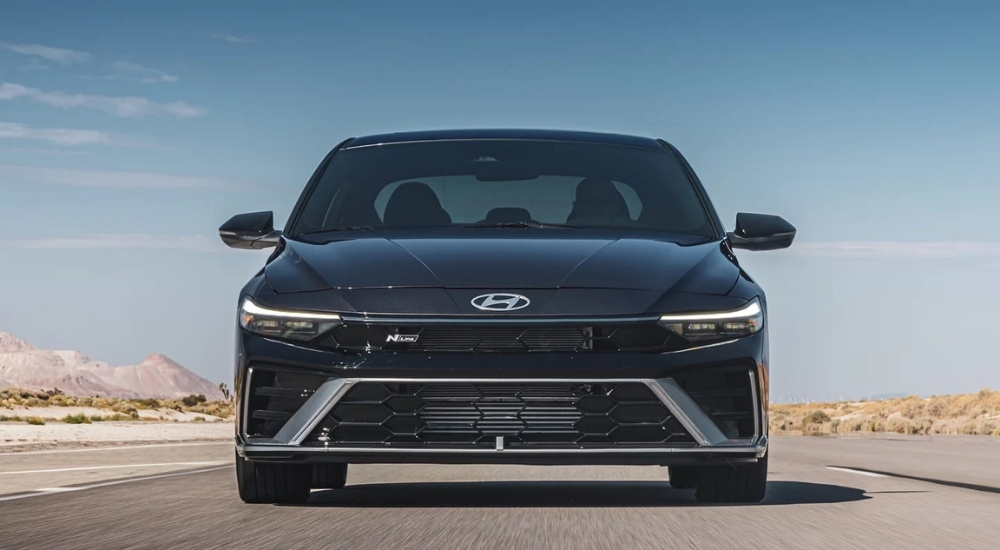 Head-on view of a black 2025 Hyundai Elantra N-Line driving on an open road.