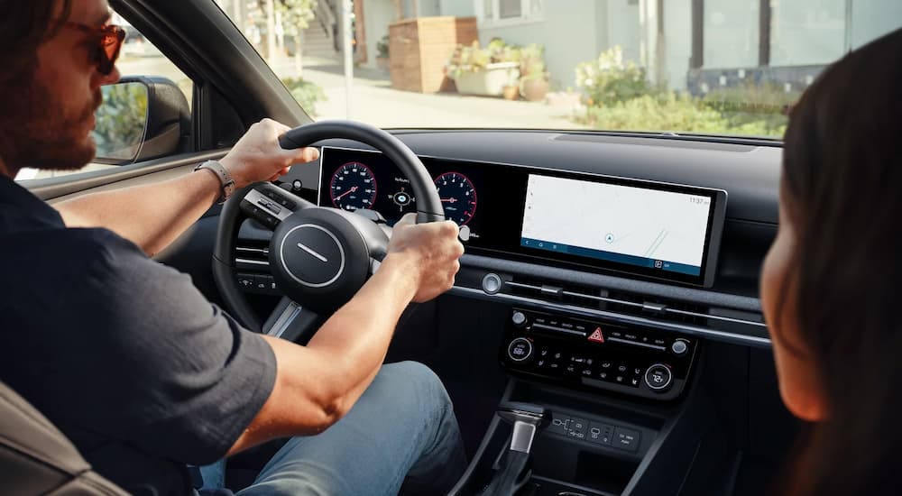 A man and a woman are driving in a 2025 Hyundai Santa Cruz Limited.