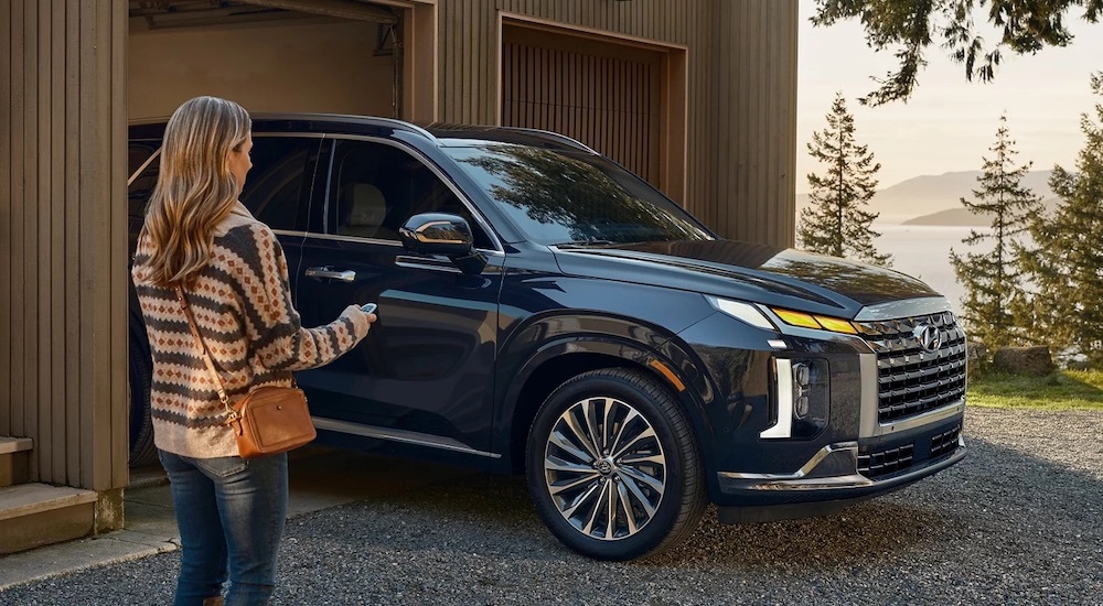 A blue 2025 Hyundai Palisade is shown from the side.