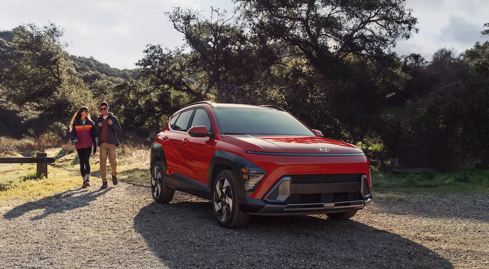 A red 2025 Hyundai Kona parked off-road after visiting a Hyundai dealer near Kingston.