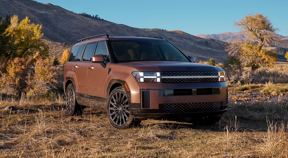 A brown 2025 Hyundai Santa Fe parked off-road.