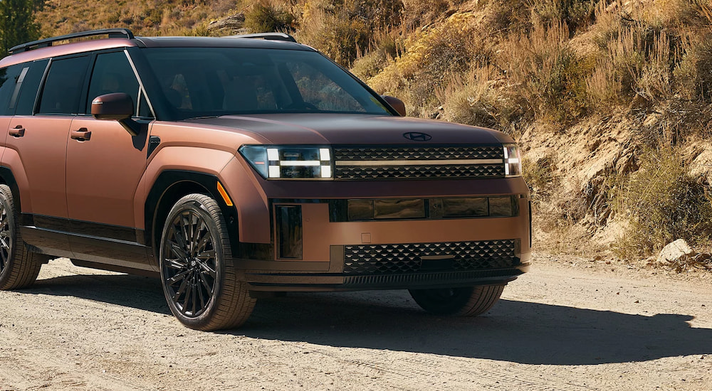 A brown 2025 Hyundai Santa Fe driving from a Hyundai dealer near Kingston.