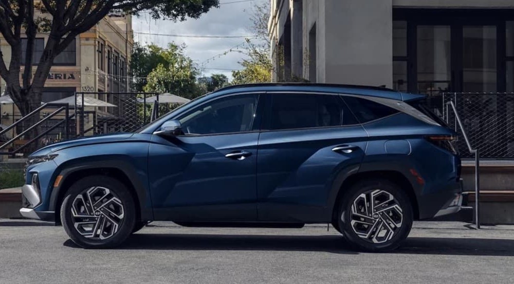 A blue 2025 Hyundai Tucson Limited parked in a city.