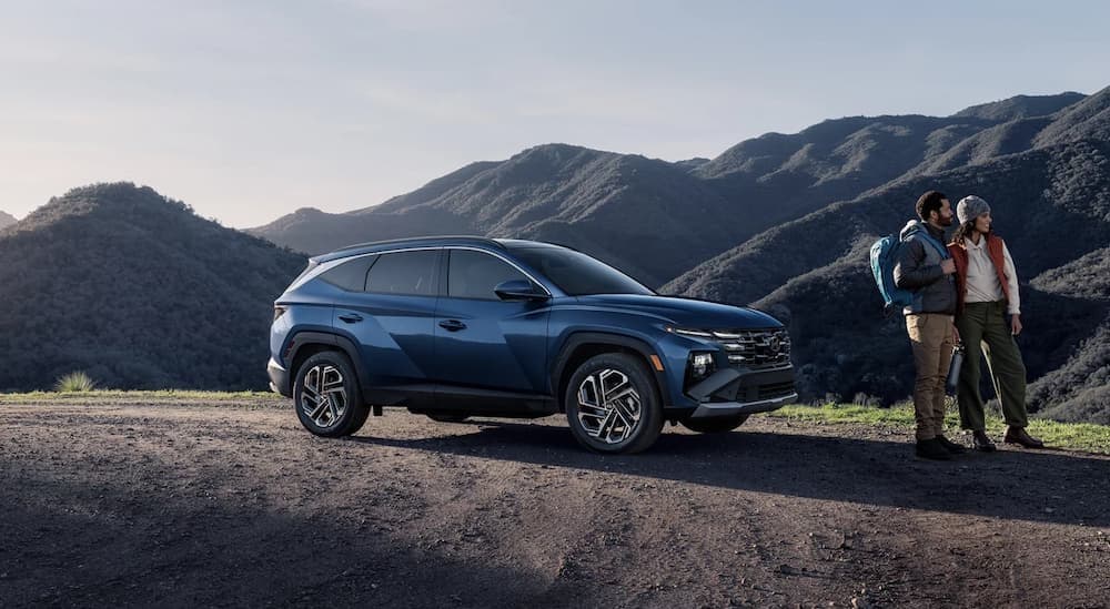 A blue 2025 Hyundai Tucson parked near a mountain range.