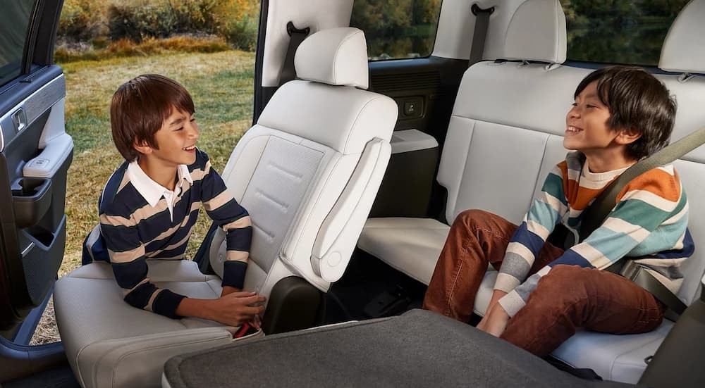 Children sitting on the white interior seating in a 2025 Hyundai Santa Fe.
