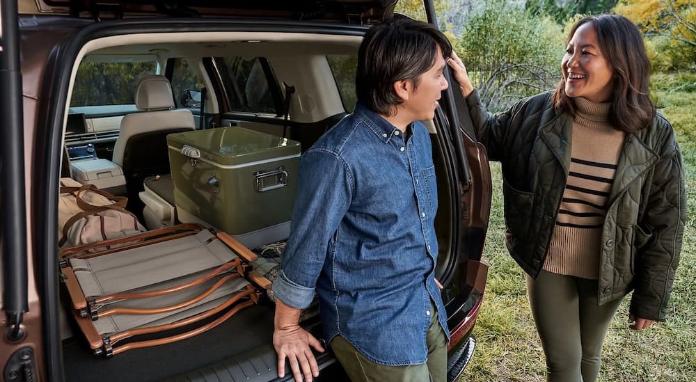 Two people near the open hatch of a copper 2025 Hyundai Santa Fe.