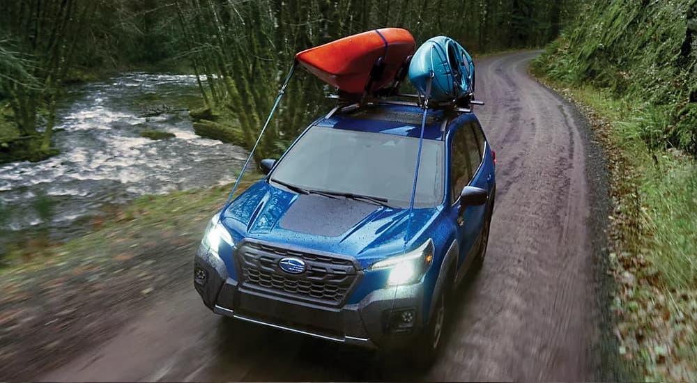 Blue 2023 Subaru Forester Wilderness driving off-road.
