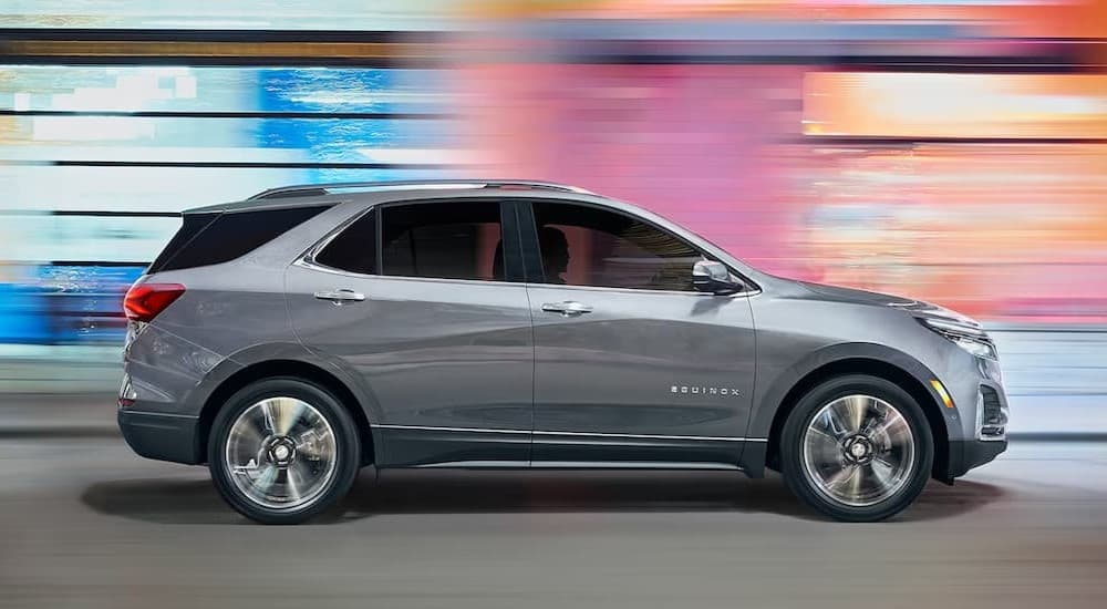 A silver 2023 Chevy Equinox LT driving in a city.