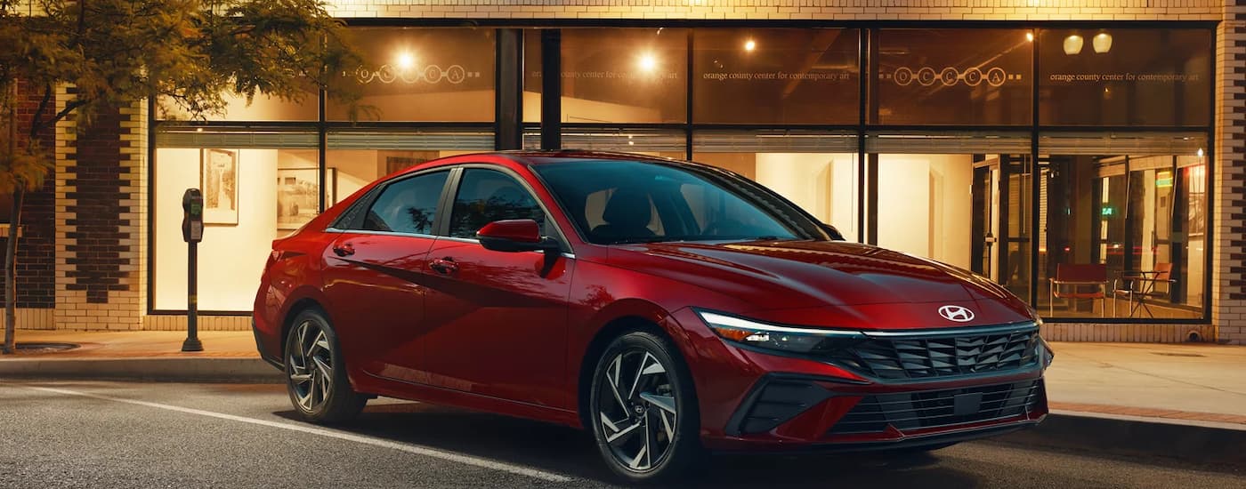 Red 2026 Hyundai Elantra parked in front of a building.
