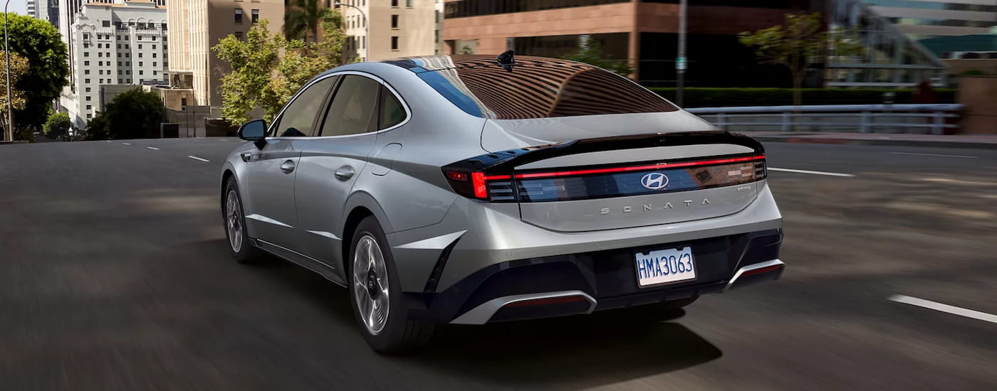 Rear of a grey 2026 Hyundai Sonata driving down a city street.