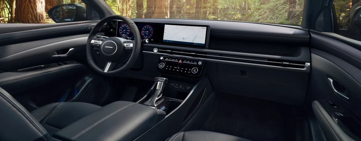 2026 Hyundai Santa Cruz front interior showing the steering wheel and infotainment.