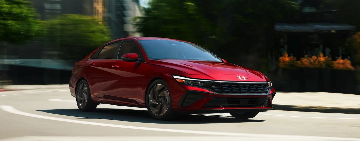 A red 2024 Hyundai Elantra Limited driving to a Hyundai dealer near Farragut.