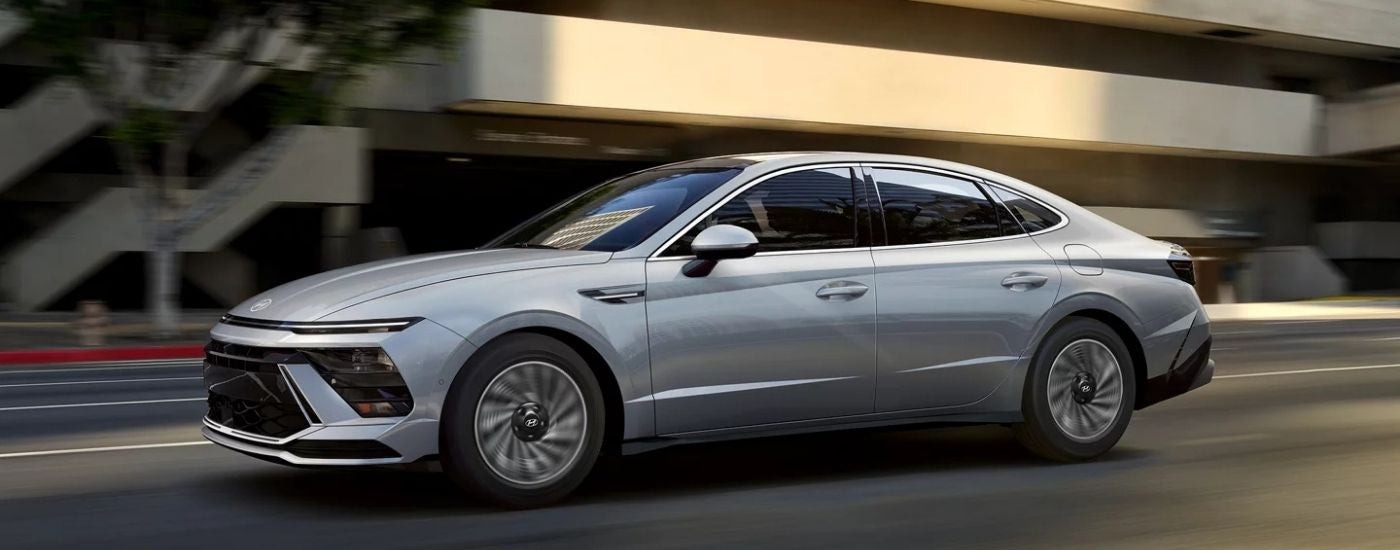 A silver 2024 Hyundai Sonata driving through the city.
