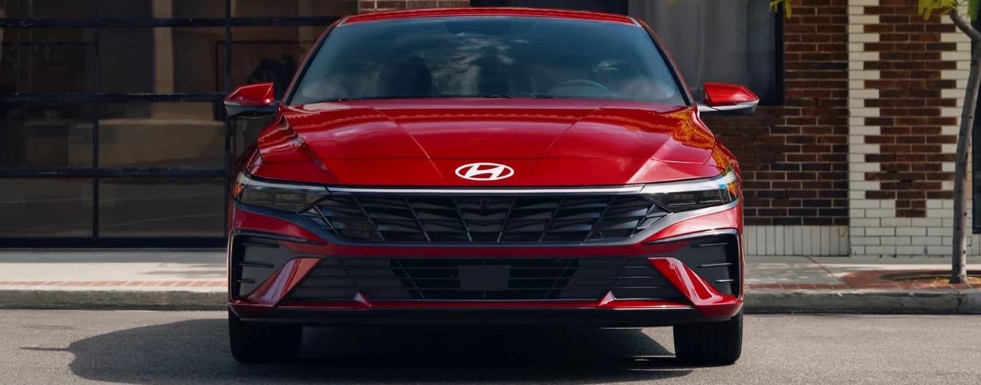 A red 2024 Hyundai Elantra Limited for sale is parked at a dealership.